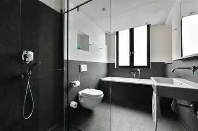 a bathroom with a toilet and a sink and a shower at The Bank Hotel in Amsterdam