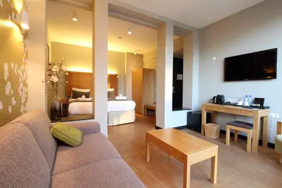 a living room with a couch and a bedroom at The Bank Hotel in Amsterdam