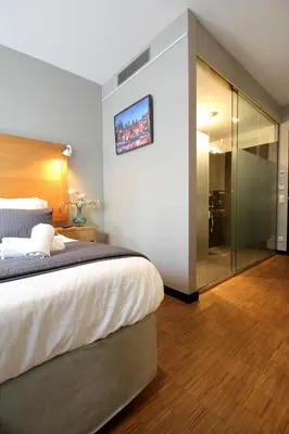 a bedroom with a large bed and a glass walk in shower at The Bank Hotel in Amsterdam