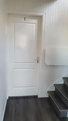 a white door in a room with stairs at Guesthouse Zandvoort in Zandvoort