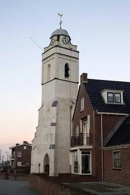 a tower with a clock on top of a building at kustappartementenkatwijk in Katwijk aan Zee