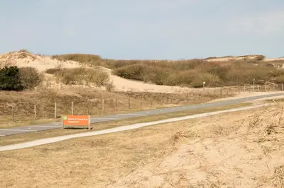 a road with a sign on the side of it at kustappartementenkatwijk in Katwijk aan Zee