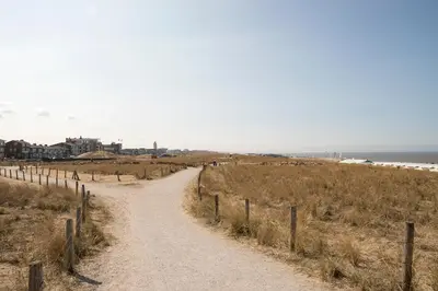 a dirt road leading to the beach at kustappartementenkatwijk in Katwijk aan Zee