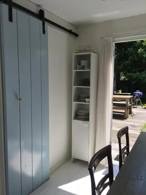 a room with a table and chairs and a sliding door at De Vuurdoorn in Bergen