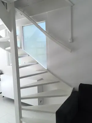 a white staircase in a room with a window at De Vuurdoorn in Bergen