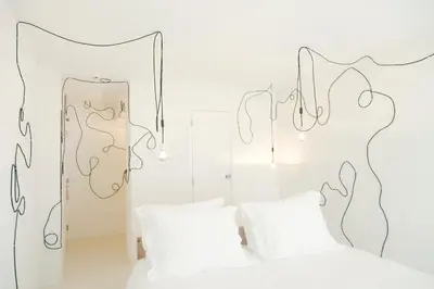 a white bedroom with a bed and a mirror at Hotel The Exchange in Amsterdam