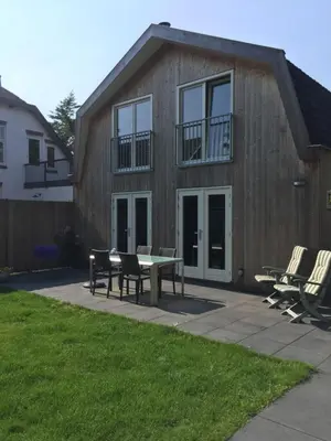 a house with a table and chairs in front of it at Het Hart in Bergen