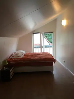 a bedroom with a bed with a large window at Het Hart in Bergen