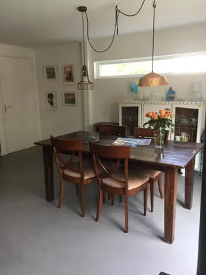 a dining room with a wooden table and chairs at Het Hart in Bergen