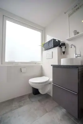 a bathroom with a toilet and a sink and a window at Bad Zandvoort in Zandvoort