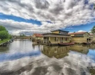 a view of a river with houses and buildings at Huisje Britt met grote tuin en veel privacy in Dirkshorn