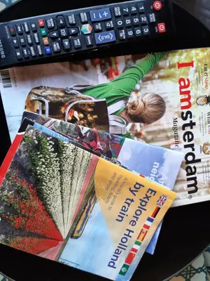 a pile of magazines sitting on a desk with a keyboard at Mi BnB Amsterdam in Amsterdam
