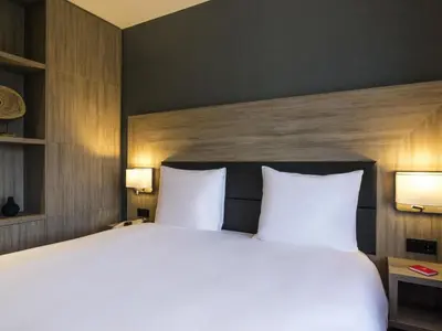 a bedroom with a large bed with two white pillows at Adagio Amsterdam City South in Amstelveen