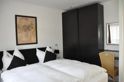 a bedroom with a bed with black and white pillows at Schelvis Apartments in Zandvoort