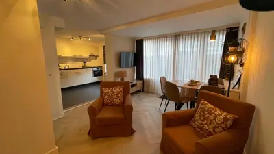 a living room with a table and chairs and a kitchen at Schelvis Apartments in Zandvoort