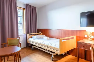 a hospital room with a bed and a table and a desk at De Rijper Eilanden in De Rijp
