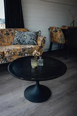 a black coffee table in a living room with a couch at Logeren aan Zee in Katwijk aan Zee