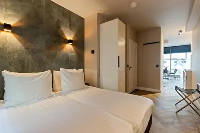 a bedroom with a large white bed with white pillows at Midtown Hotel Twin Studio in Amsterdam
