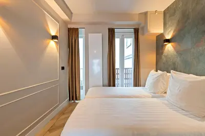 a hotel room with two beds and a window at Midtown Hotel Twin Studio in Amsterdam
