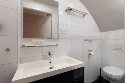 a white bathroom with a sink and a toilet at Midtown Hotel Twin Studio in Amsterdam
