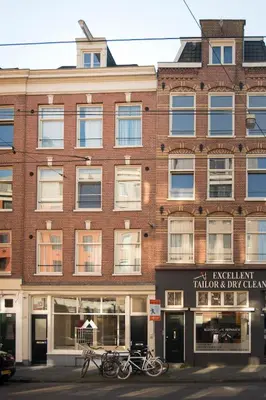 a large brick building with bikes parked in front of it at Midtown Hotel Twin Studio in Amsterdam