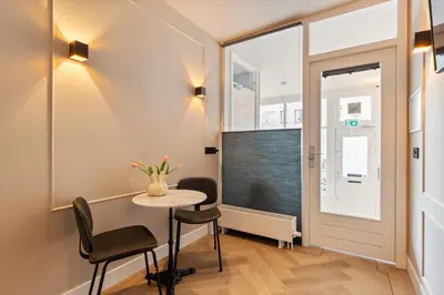 a small room with a table and chairs and a window at Midtown Hotel Twin Studio in Amsterdam