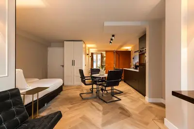 a room with a bed and a table and chairs at Midtown Hotel Royal Room in Amsterdam