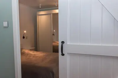 a bedroom with a bed and a door with a mirror at Annadora Beach House - Private Parking in Zandvoort