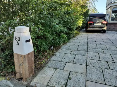 a pole with a sign on it next to a street at Annadora Beach House - Private Parking in Zandvoort