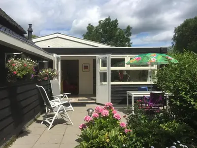 a patio with a table and chairs and an umbrella at Lekerweg 32 in Wijdenes