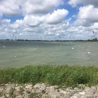a large body of water with birds flying in the sky at Lekerweg 32 in Wijdenes