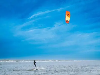a man is flying a kite on the beach at Holiday Home Bergen near Beach & Dunes in Bergen aan Zee