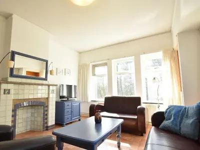 a living room with a couch and a fireplace at Holiday Home Bergen near Beach & Dunes in Bergen aan Zee