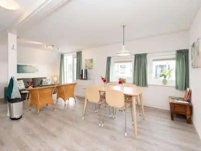 a dining room and living room with a table and chairs at Apartment in Schoorl near Dunes in Schoorl