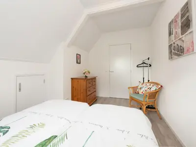 a bedroom with two beds and a chair at Apartment in Schoorl near Dunes in Schoorl