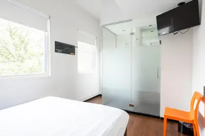 a bedroom with a white bed and a window at easyHotel Amsterdam City Centre South in Amsterdam