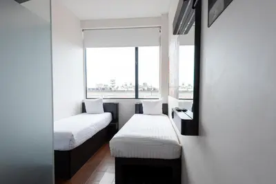 a small room with two beds and a window at easyHotel Amsterdam City Centre South in Amsterdam