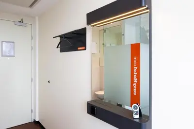 a bathroom with a mirror and a toilet at easyHotel Amsterdam City Centre South in Amsterdam