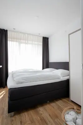 a bed in a bedroom with a large window at Costa in Zandvoort