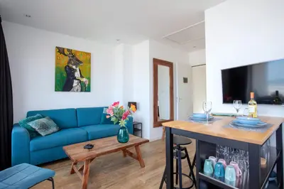 a living room with a blue couch and a table at Costa in Zandvoort