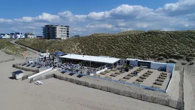 a restaurant on the beach next to a sandy beach at Costa in Zandvoort