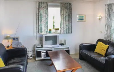 a living room with two couches and a tv at Huisje Zand En Water in Egmond aan Zee