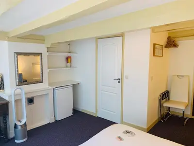 a room with a bed and a desk and a mirror at Amsterdam Central Guest House in Amsterdam