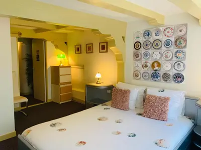 a bedroom with a bed with plates on the wall at Amsterdam Central Guest House in Amsterdam