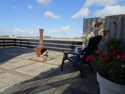 a vase and a chair sitting on a patio at Molenzicht in Sint Maarten