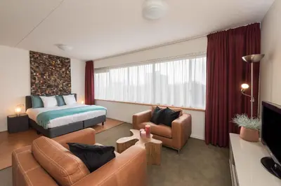 a hotel room with a bed and a living room at Htel Serviced Apartments Amstelveen in Amstelveen
