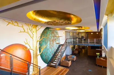 a lobby with a staircase and a tree mural at Htel Serviced Apartments Amstelveen in Amstelveen