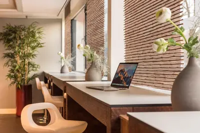 a row of tables with a laptop computer on them at Htel Serviced Apartments Amstelveen in Amstelveen