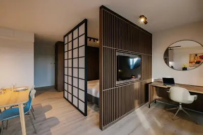 a room with a desk and a bed and a mirror at Htel Serviced Apartments Amstelveen in Amstelveen