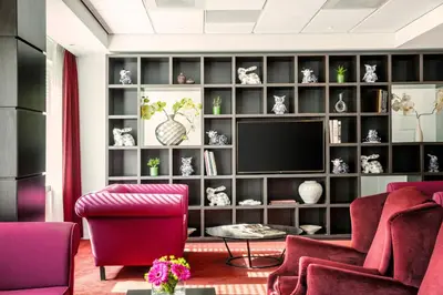 a living room with a large book shelf with a television at Holiday Inn Express Amsterdam - Sloterdijk Station by IHG in Amsterdam